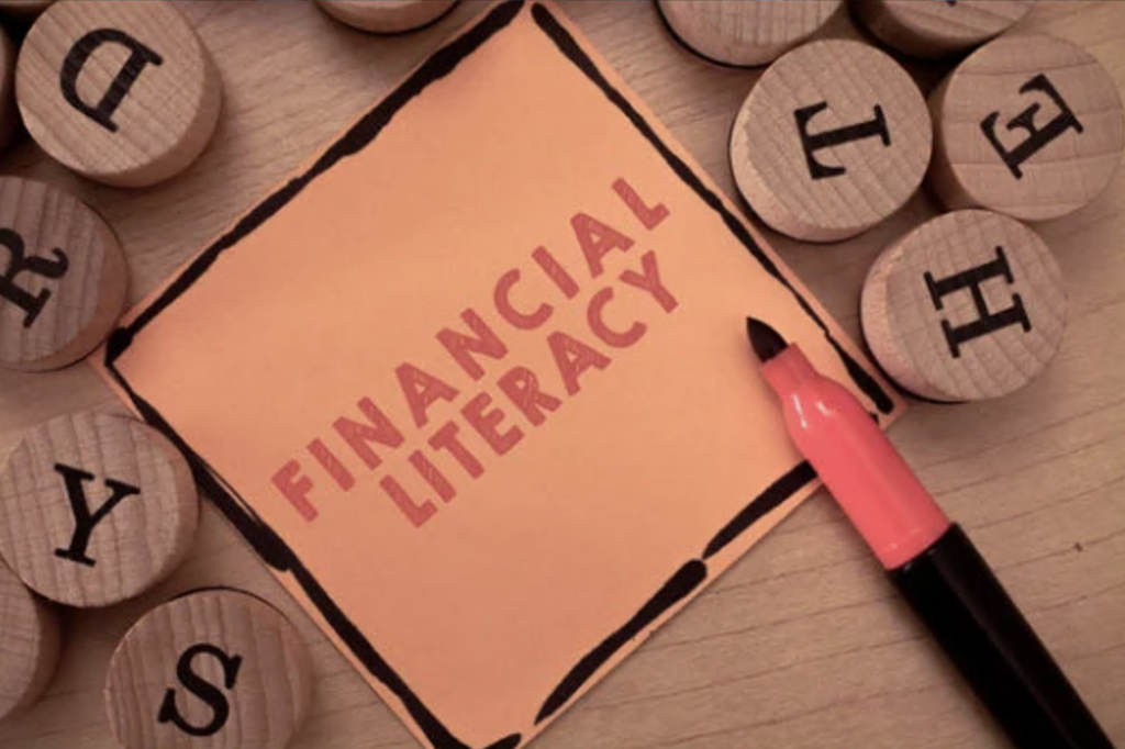 financial literacy written in red on a dark yellow sticky note