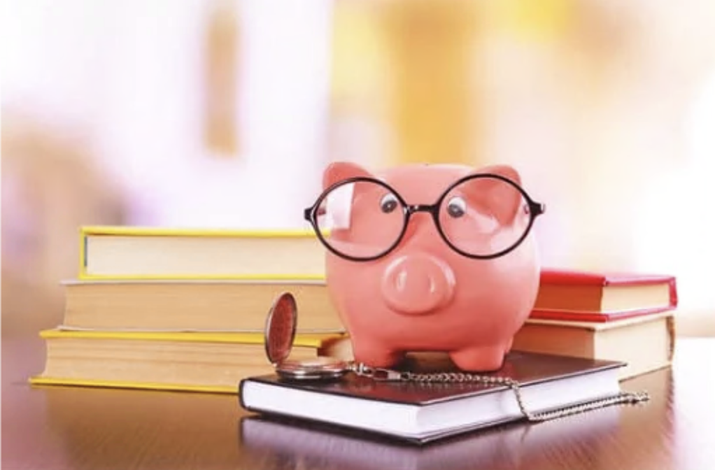 piggy bank with glasses on top of a book